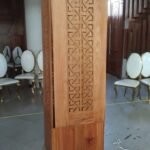 Structural column clad in hardwood with laser-cut fretwork panels