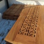 Finished hardwood door with carved fretwork panel loaded for delivery