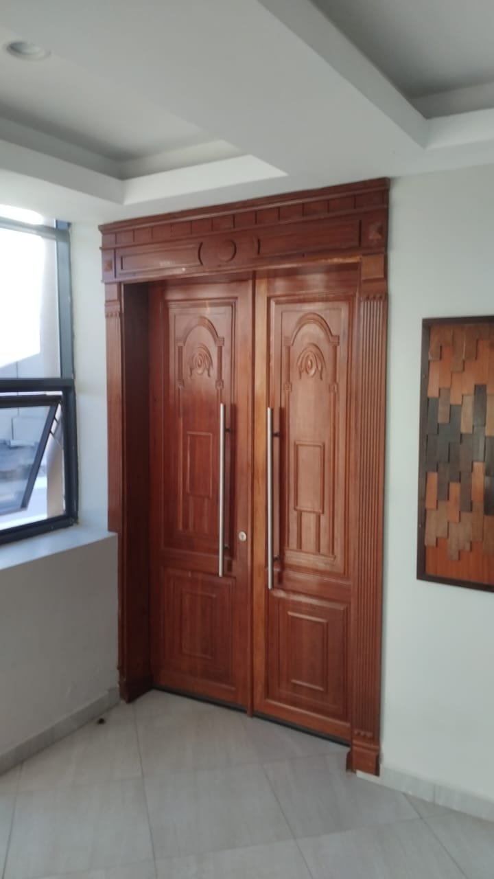 Hand-carved solid hardwood double doors with moulded frame and cornice