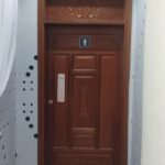 Hardwood door with a carved decorative transom panel above