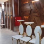 Close view of a backlit hexagon timber feature wall with cocktail tables
