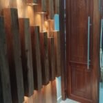 Slatted hardwood feature wall and carved door in a completed Simba Umeme interior