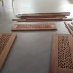 Carved fretwork timber panels laid out during fabrication