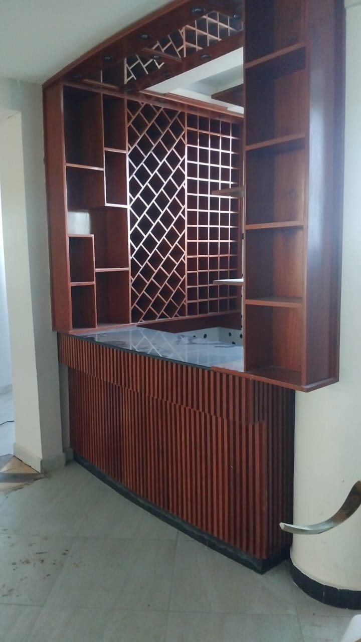 Built-in timber bar unit with wine rack and fluted counter front made by Simba Umeme