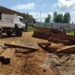 Timber being offloaded from the Simba Umeme truck at a project site