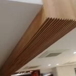 Slatted timber ceiling bulkhead running across a finished interior
