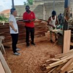 Stephen Benedict Kessy, Managing Director of Simba Umeme, with a client at the company sawmill in Dar es Salaam