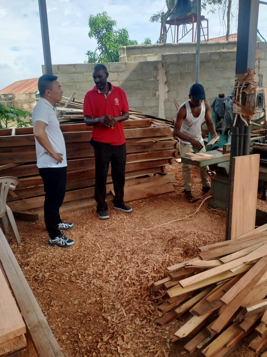 Stephen Benedict Kessy, Managing Director of Simba Umeme, with a client at the company sawmill in Dar es Salaam