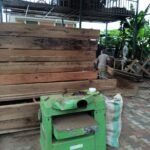 Seasoned hardwood stock and planing machinery in the Simba Umeme workshop yard